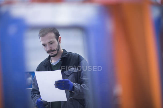 Young adult male Engineer looking at paperwork — Stock Photo