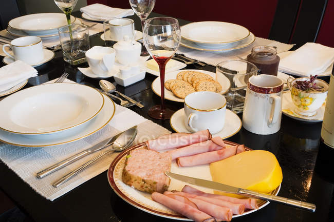Table de dîner servi avec assiette de jambon et vaisselle — Photo de stock