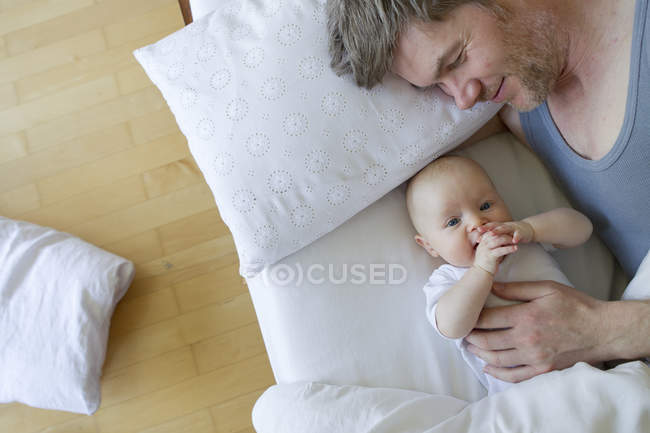Pai e bebê filha deitada na cama — Fotografia de Stock