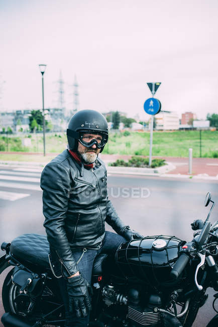 Maduro masculino motociclista sentado na motocicleta na estrada — Fotografia de Stock