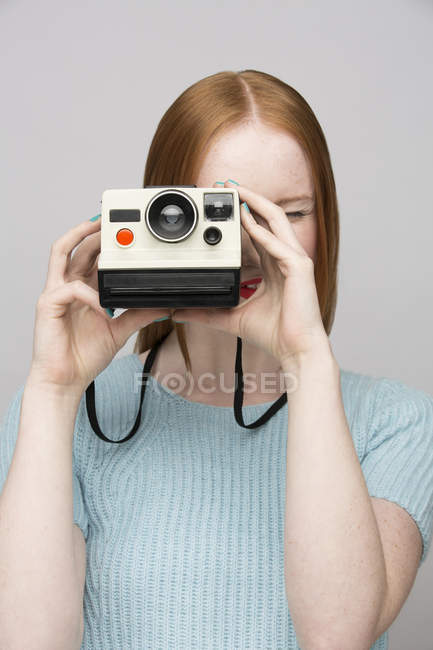 Jeune femme avec caméra polaroïd — Photo de stock