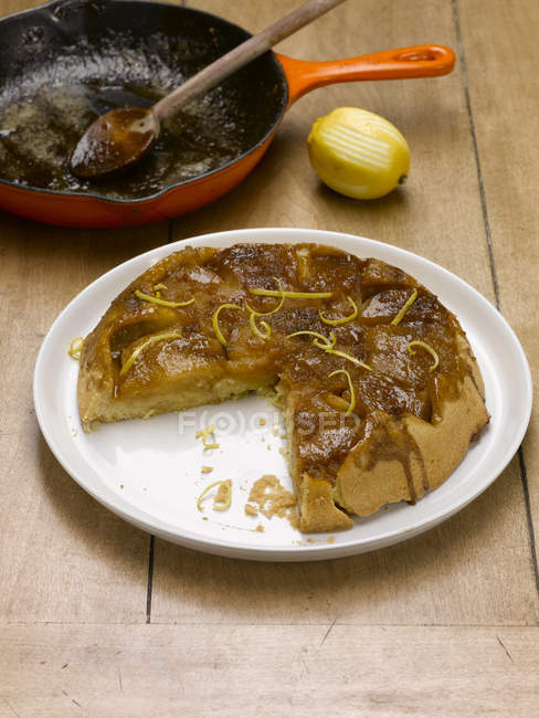 Яблочный пирог татин с кастрюлей и лимоном на столе — стоковое фото