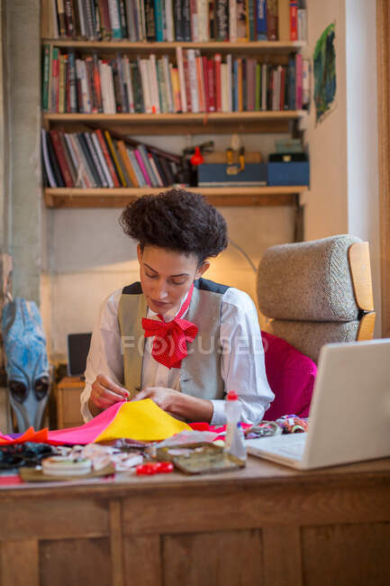 Designer sewing at desk in office — Stock Photo
