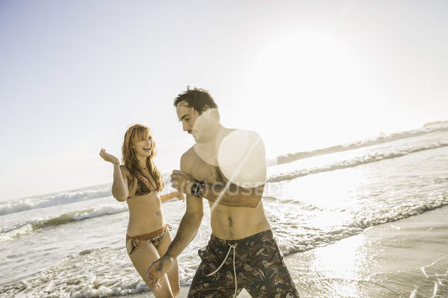 Mitte erwachsene Frau im Bikini spielt mit Freund am Strand, Kapstadt, Südafrika — Stockfoto