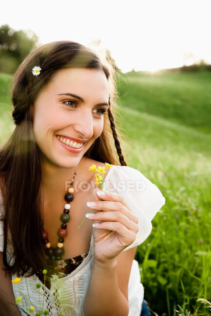 Donna sorridente che indossa un fiore tra i capelli — Foto stock