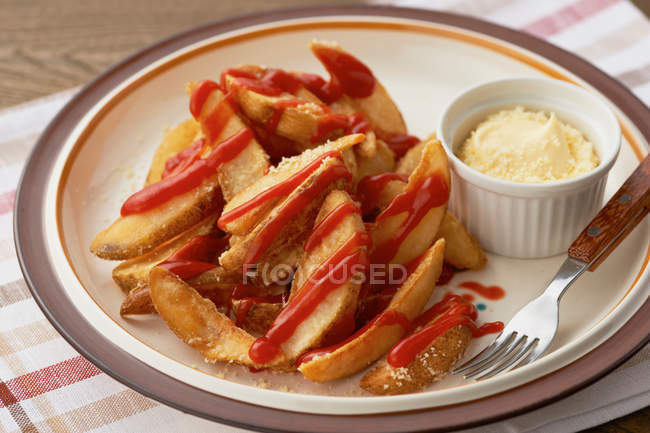 Plate with chips covered in tomato sauce — Stock Photo