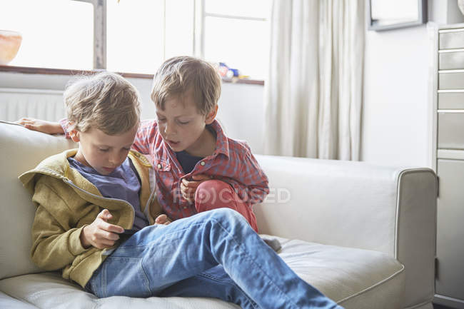 Zwei kleine Brüder mit Smartphone zu Hause — Stockfoto