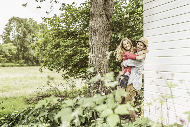 Молодая пара обнимается в саду — стоковое фото