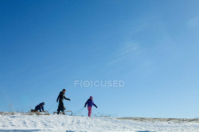 Mother and two children with toboggan — Stock Photo