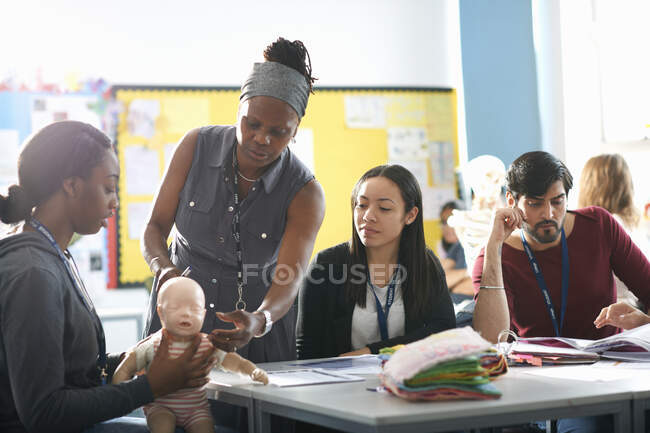 Profesor que habla con estudiantes universitarios en la clase de cuidado infantil - foto de stock