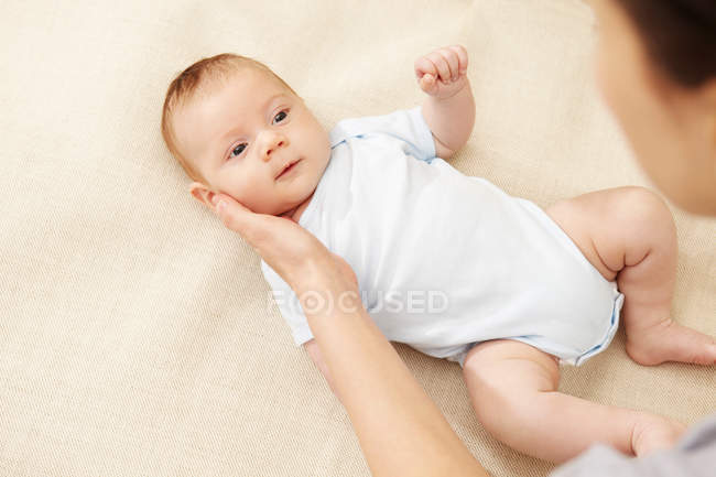 Mother touching baby boy's cheek — Stock Photo