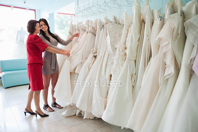 Mutter und Tochter schauen sich Brautkleider an — Stockfoto