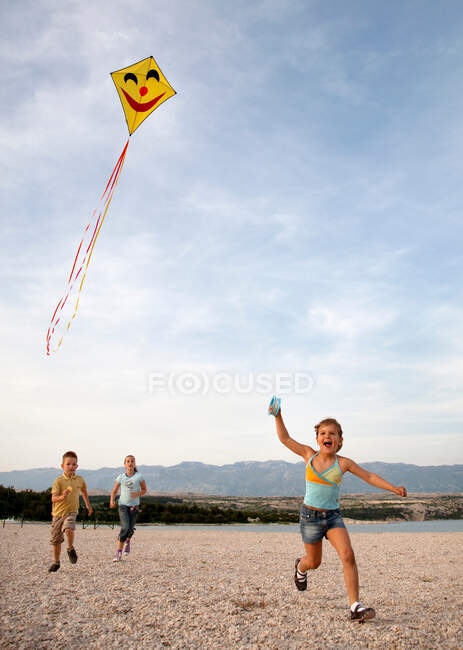 Kinder lassen Drachen am Strand steigen — Stockfoto