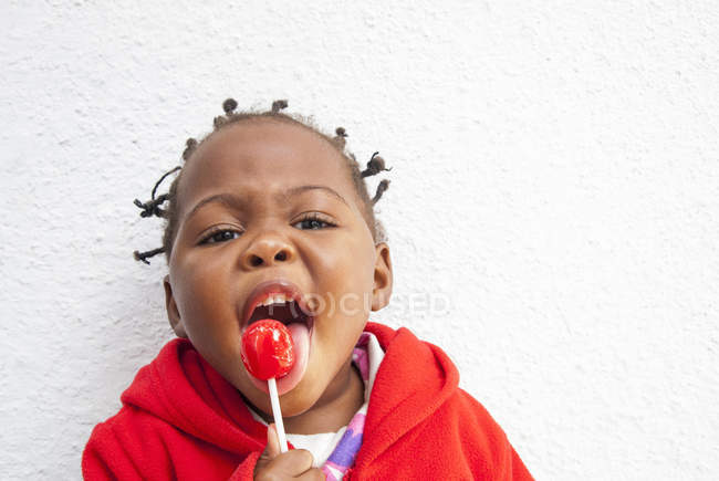 Porträt eines weiblichen Kleinkindes, das Lutscher genießt — Stockfoto