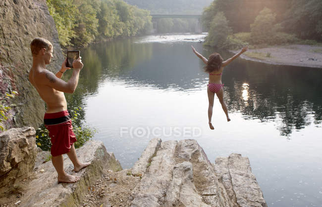 Junges Paar fotografiert Sprung von Felsvorsprung, Hamburg, Pennsylvania, USA — Stockfoto