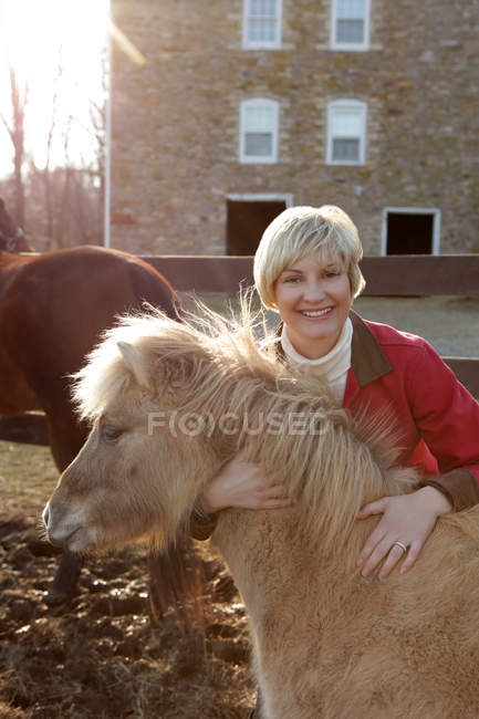 Portrait de femme adulte moyenne debout avec poney — Photo de stock