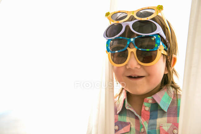 Fille portant quatre paris de lunettes de soleil — Photo de stock