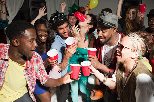 Молоді люди з пластиковими чашками на вечірці — стокове фото