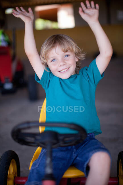 Niño montando go-kart en el garaje - foto de stock