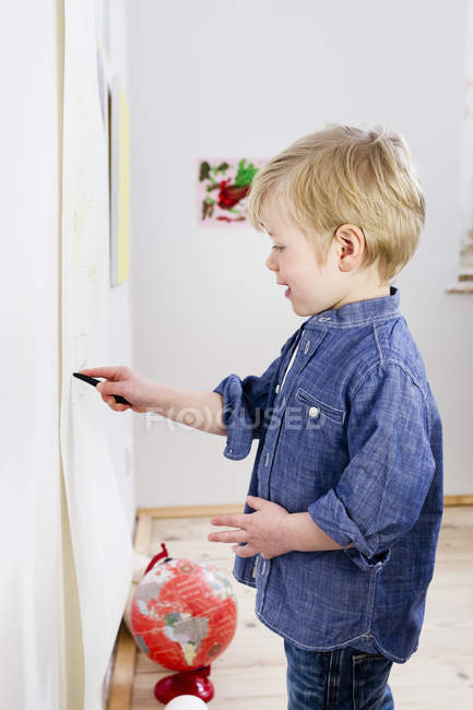 Junge zeichnet an Wand — Stockfoto