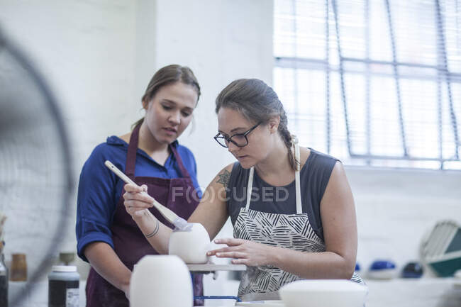 Cape Town, South Africa, young woman painting out on bowl in ceramic workshop — Stock Photo