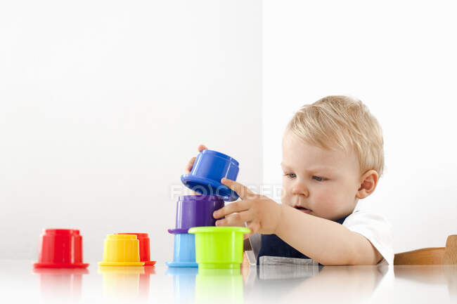 Niño jugando con tazas de apilamiento - foto de stock