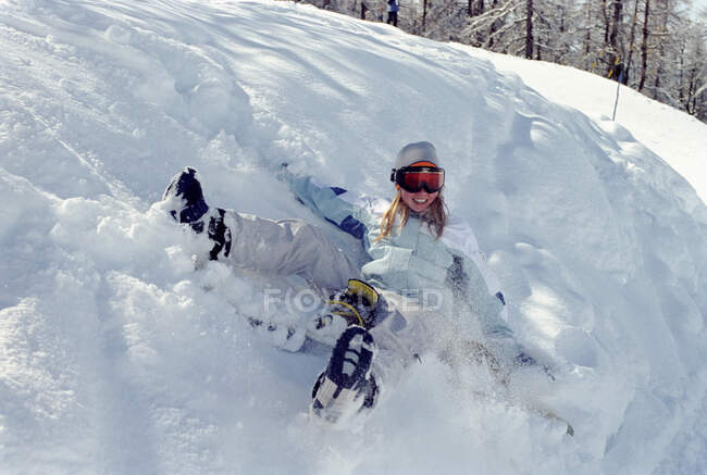 Une fillette roule dans la neige — Photo de stock
