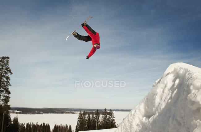 Male snowboarder upside down during mid air jump — Stock Photo