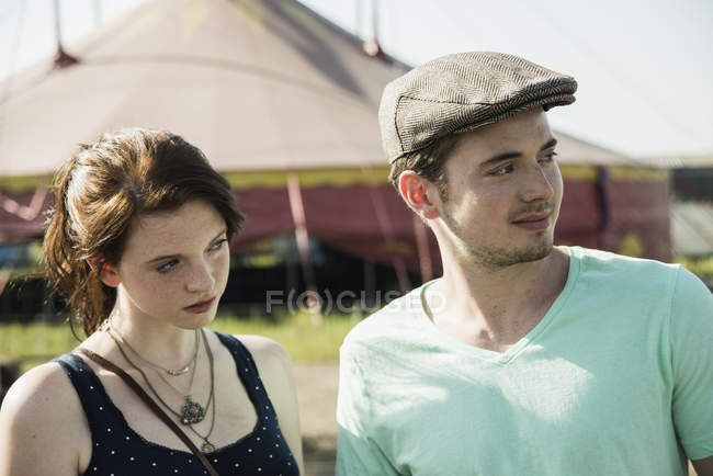 Jovem casal olhando e distraído na feira — Fotografia de Stock