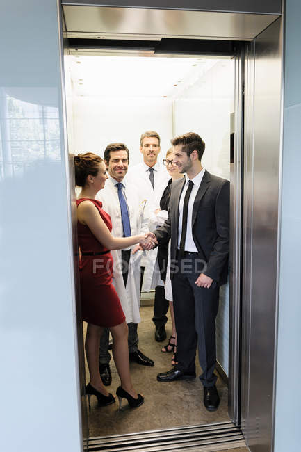 Médicos y empresarios en ascensor - foto de stock