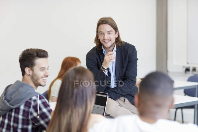 Преподаватель мужского пола беседует со студентами в классе колледжа высшего образования — стоковое фото