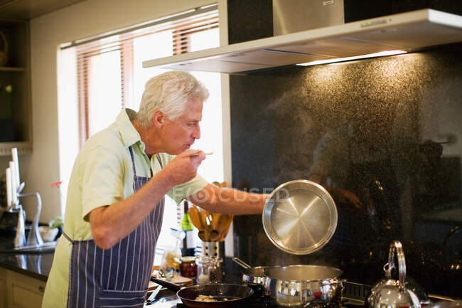 Uomo più anziano cucina in cucina — Foto stock