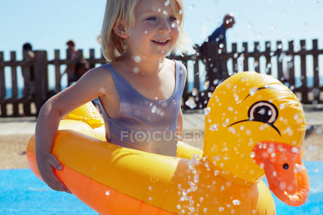 Niño con flotador en forma de pato en la piscina - foto de stock