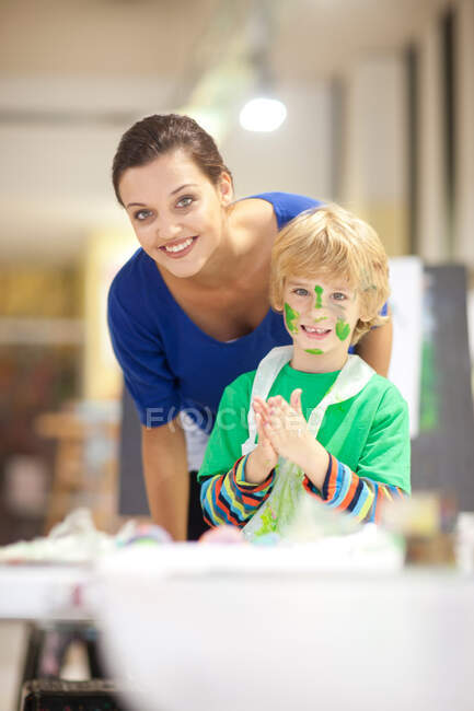 Mujer joven y niño en clase de arte - foto de stock