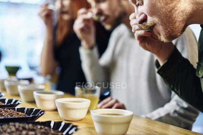 Люди тестирование кофе по вкусу — стоковое фото