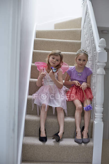 Chicas disfrazadas esperando en la escalera - foto de stock