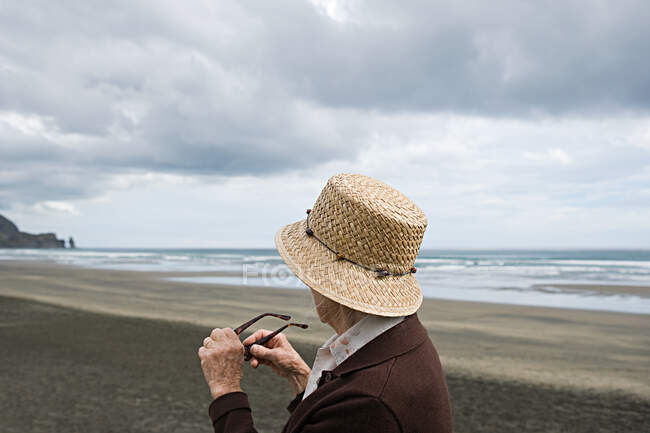 Старша жінка на пляжі Піха, Окленд. — стокове фото