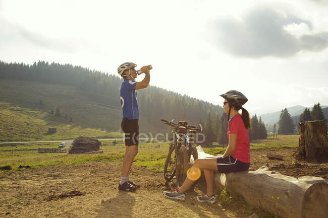 Hombre y mujer descansando con bicicletas de montaña, Estiria, Austria - foto de stock