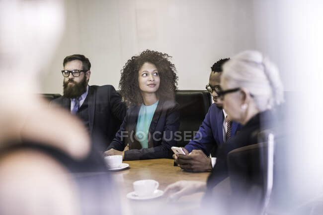 Ventana vista de la mujer de negocios y hombres de negocios en reunión de la junta directiva - foto de stock