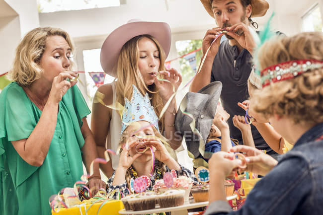 Drei-Generationen-Familie bei Kindergeburtstag bläst Party-Trillerpfeifen — Stockfoto