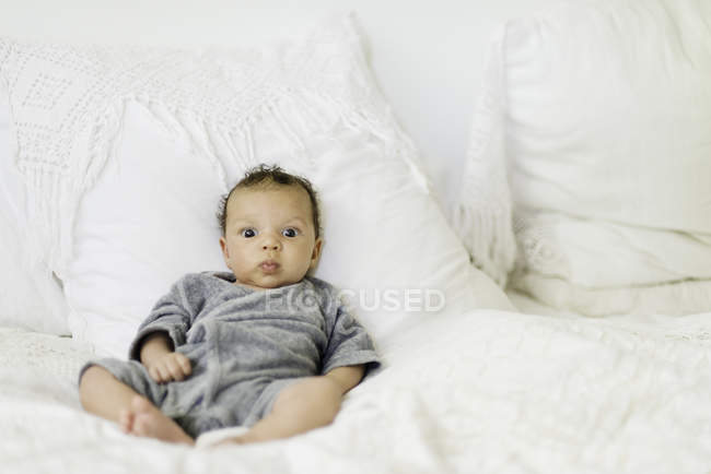Baby sitting up on bed — Stock Photo