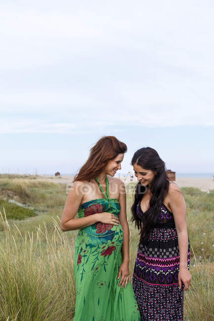 Беременная женщина и друг, стоящие в поле — стоковое фото
