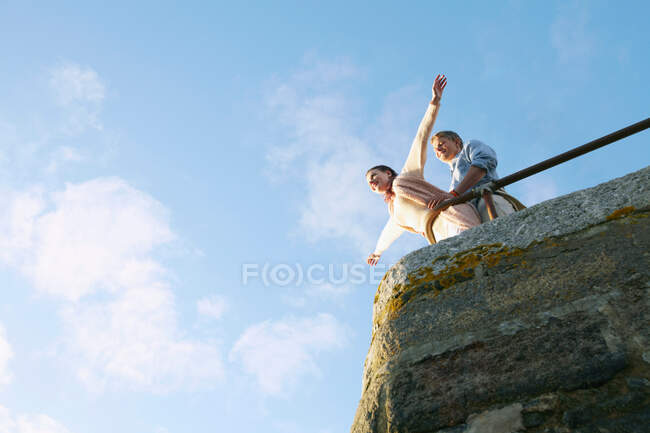 Couple playing on edge of stone wall — Stock Photo