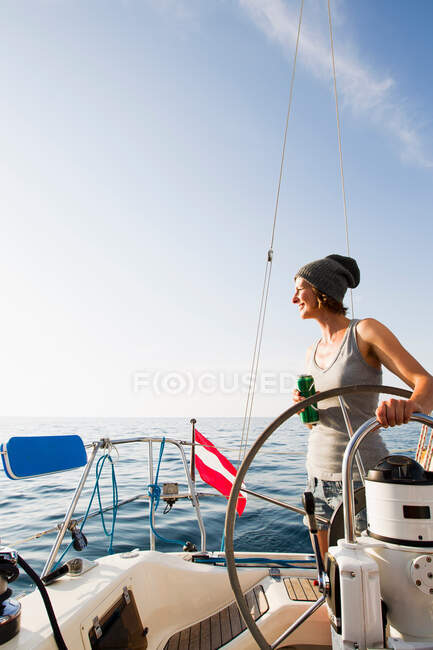 Усміхнена жінка керує на човні — стокове фото