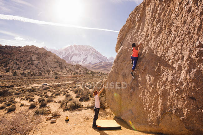 Couple climbing rock face, Buttermilk Boulders, Bishop, California, USA — Stock Photo