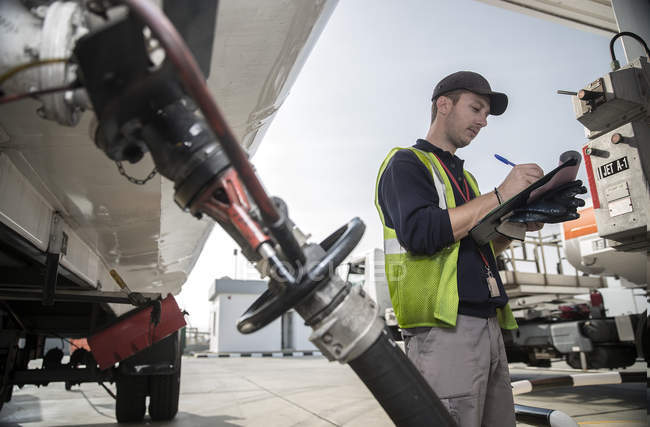 Trabalhador do sexo masculino fazendo inspeção no depósito de combustível — Fotografia de Stock