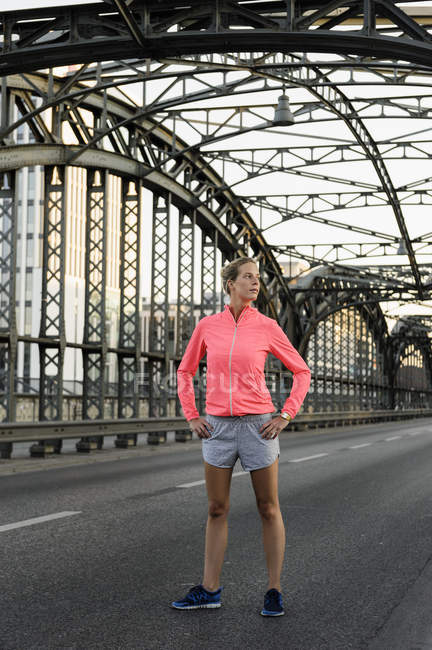 Jovem corredor do sexo feminino exercitando na ponte — Fotografia de Stock