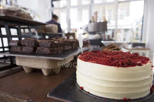 Pastel de terciopelo rojo y brownies de chocolate en el mostrador de café - foto de stock