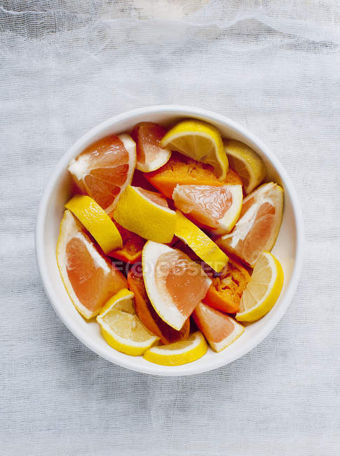 Slices citrus fruit in white bowl — Stock Photo