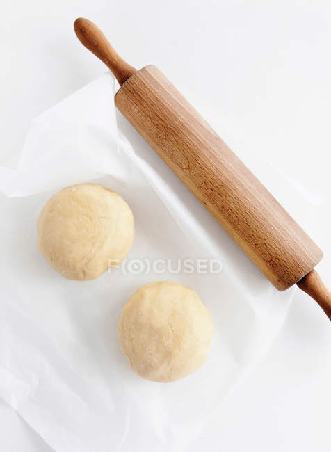 Balls of dough and rolling pin on table — Stock Photo
